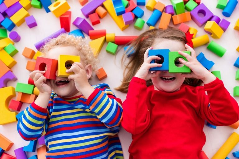 The Importance of Encouraging a Child’s Imagination Two kids lying down with blocks on their faces - Your ELC