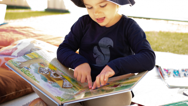 storytime A Kid Reading a Story Book -Importance of Storytelling - Your Early Learning Centre Blog Image