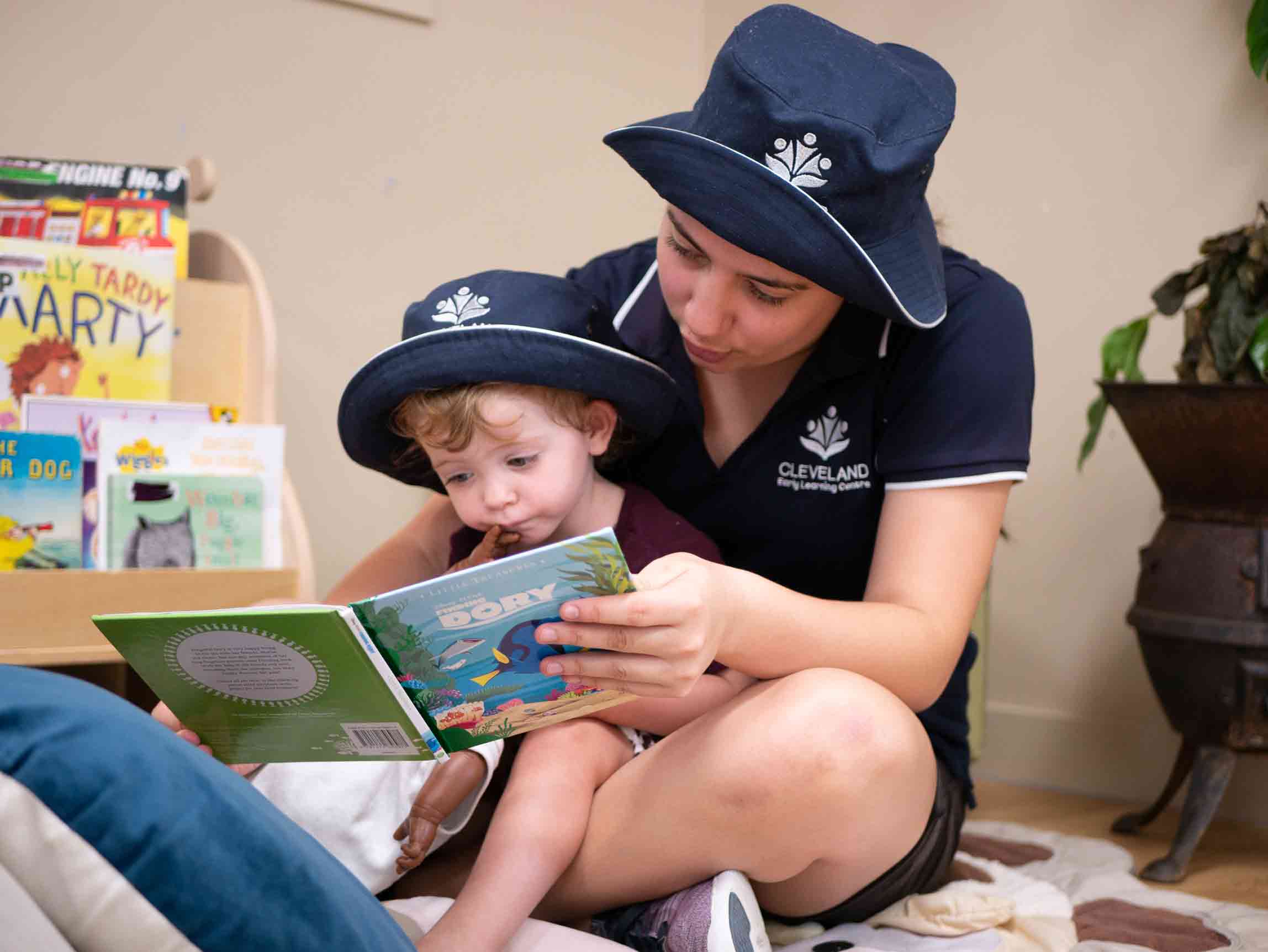 Teacher reading a storybook to a kid - Your Early Learning Centre