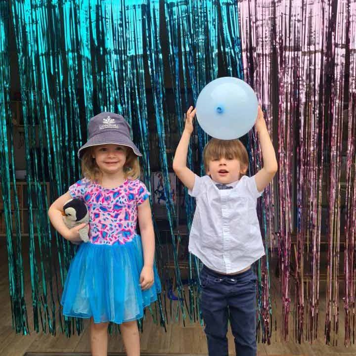 Two kids in a photo op with streamers on background - Cannon Hill Your ELC Christmas Celebration