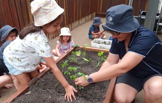 Kids with teacher planting vegetables - Doolandella November 2021 Newsletter - Your ELC