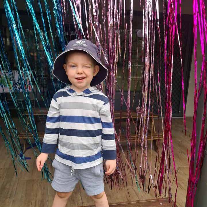 A boy smiling at the camera with streamers on background - Cannon Hill Your ELC Christmas Celebration