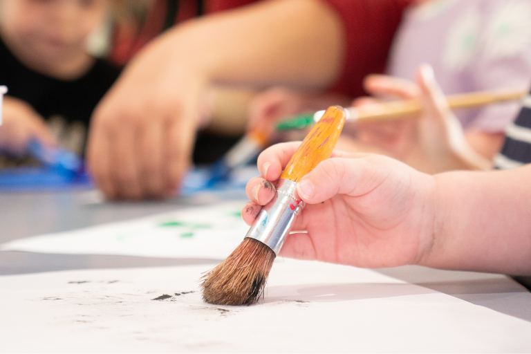 Gross Motor Skills A kid's hand holding a paint brush - Your ELC blog image