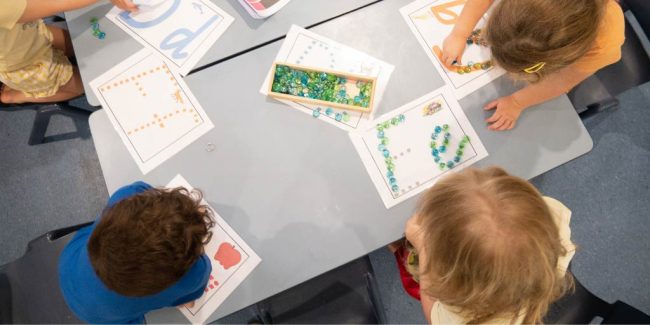Langauge-Learning-at-Key-Ages Kids at the table learning alphabets - Language development in kids guidance for parents - Your ELC