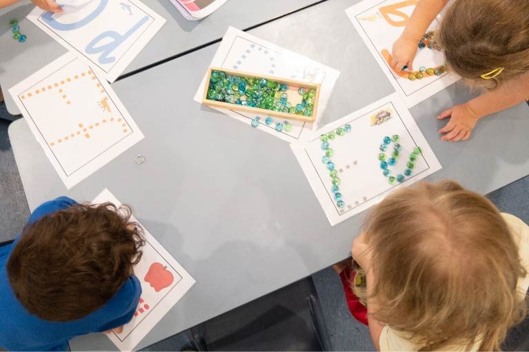 Langauge-Learning-at-Key-Ages Kids at the table learning alphabets - Language development in kids guidance for parents - Your ELC