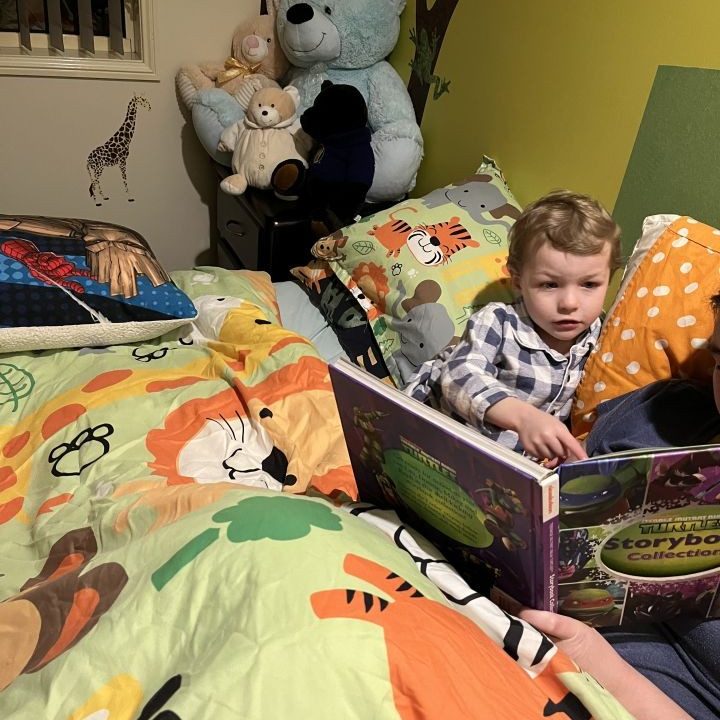 A teacher reading a book to a child - Doolandella Early Learning Centre