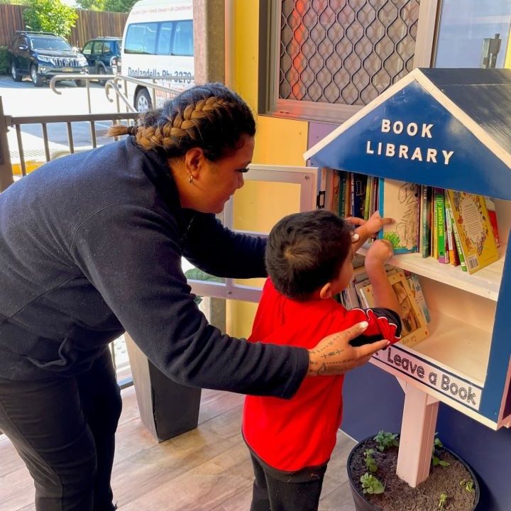 Teacher letting a kid get a book in the new book library - Doolandella Early Learning Centre