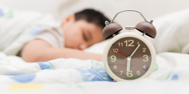 Why Routines Are Important for Children A sleeping kid with an alarm clock - Your ELC