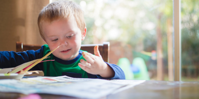 School Holidays Blog A child reading on a table - Your ELC blog image