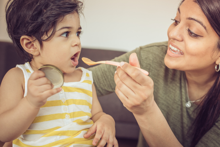 Fussy eaters A mother spoon feeding her child - Tips for supporting fussy eaters - Your ELC blog image
