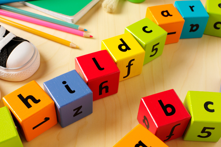 What To Know Before Your Child Starts Childcare Playing blocks with letters | Your ELC blog image